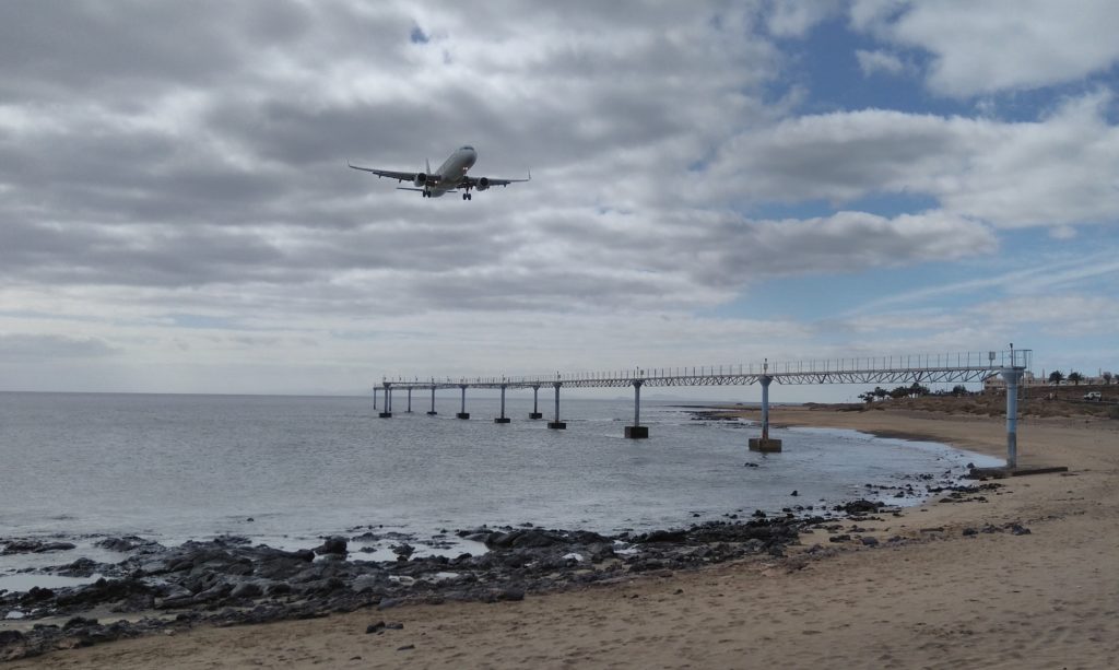 Photo of a passenger plane coming into land over a beach in Lanzarote.