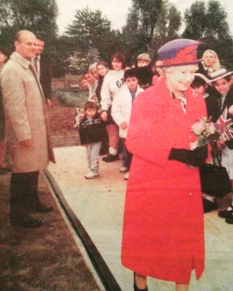 Sharon's photograph of her behind the Queen in a white GAP sweater, holding her son James as Glen stands on the carpet