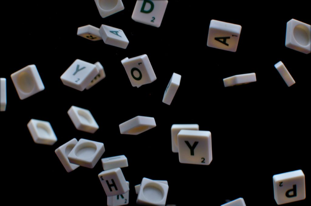 Scrabble tiles falling in front of a black background.